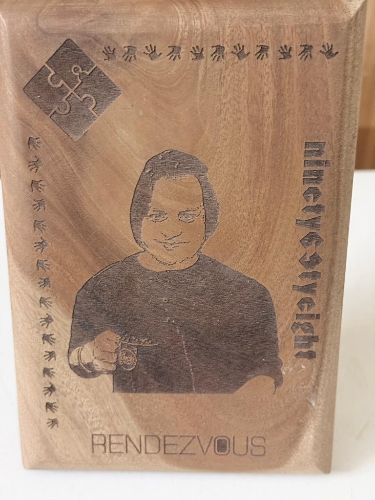 Handcrafted wooden tribute plaque with engraved portrait of perfumer Eliyash Hossain at Ninety Eight Rendezvous